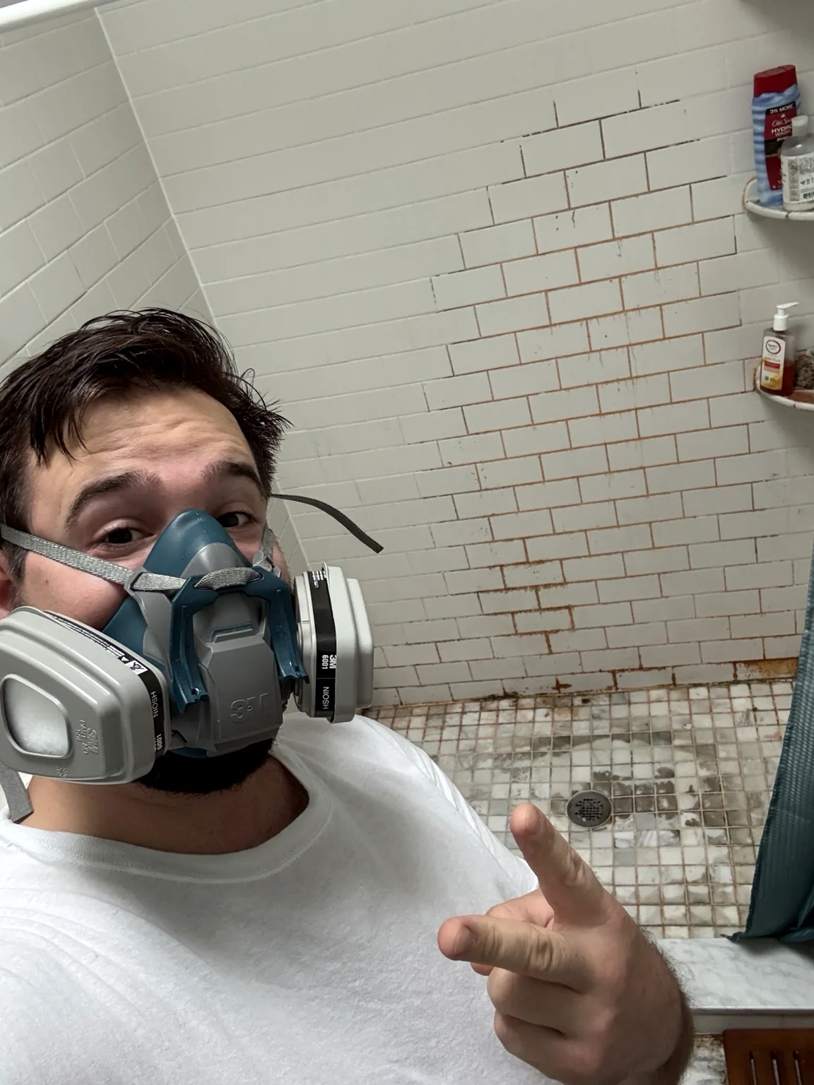 Worker wearing a respirator during shower restoration